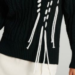 Maglione a trecce di colore nero, con inserto handmade di cordoncino bianco laterale che ricrea un effetto frangia. Questo maglione è realizzato in parte con lana d'alpaca che garantisce al capo morbidezza e un calore avvolgente. La modella, alta 1,74, indossa la taglia S. Questo prodotto è interamente made in Italy, garantendo la qualità e l'artigianalità italiane.