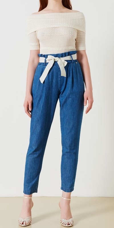 Pantaloni modello carota con vita alta arricciata, realizzato in 100% cotone. In vita sono presenti i passanti e una cintura rimovibile con fiocco in gros grain, le tasche sono alla francese. 
La vestibilità è morbida e non faciante, adatto quindi a diverse fisicità. Il capo è interamente made in Italy. La modella è alta 1,77 ed indossa la taglia S.