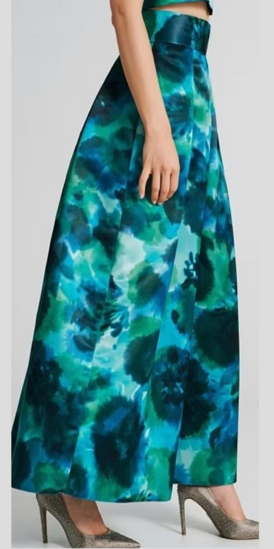 Gonna lunga modello a ruota, realizzata in raso. La gonna ha un fascione alto che valorizza il punto vita. Il capo ha delle pinces a partire dall'alto che regalano movimento e volume all'intera figura. Abbina la maxi gonna al crop top nel medesimo tessuto e fantasia, per un completo da cerimonia alternativo e super-chic. Il capo è interamente made in Italy.