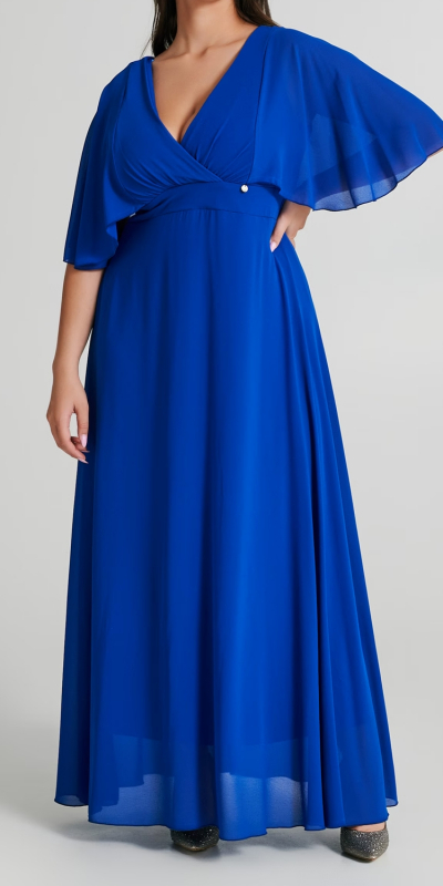 Abito Curvy lungo, stile impero realizzato in georgette. Il tessuto principale contiene almeno il 100% di poliestere riciclato. 
L'abito ha il tessuto doppiato nella parte superiore con profondo scollo a V incrociato. Il capo è dotato di una sottoveste lunga che garantisce la giusta coprenza. Romantiche maniche ad aletta molto ampie che regalano movimento all'intera figura. 
Sul retro è possibile legare un fiocco in vita per valorizzare la silhouette, chiusura tramite zip. 
Abito elegante da cerimonia da indossare con una stola o un blazer corto. Il capo è prodotto interamente in Italia. La modella è alta 1,72 ed indossa la taglia 48.