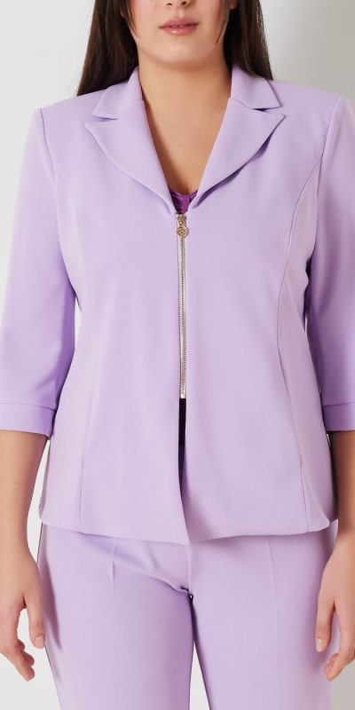 Giacca curvy in tessuto scuba mano crepe sfoderata. Questo particolare tessuto a maglia conferisce elasticità e comfort. Modello sfiancato con maniche 3/4. 
Rever classico e chiusura zip sul centro davanti tipo chiodo. 
Colore viola lilla. Il capo è interamente realizzato in Italia. 
La modella è alta 1,79 e indossa una taglia 46.