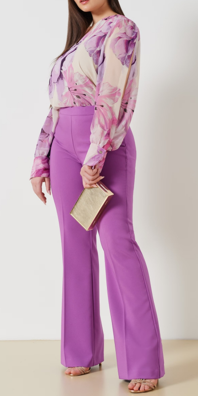 Blusa curvy in tessuto georgette stampa maxi fiore. Modello scollo a V morbido sui fianchi con davanti foderato. Maniche lunghe con polso camicia. Colore variante lilla. Il capo è interamente realizzato in Italia. La modella è alta 1,72 e indossa una taglia 48.