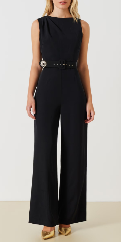 Tuta smanicata, con pantaloni palazzo. La tuta è realizzata in tessuto fluido ed è leggermente drappeggiata su una spalla. Cintura monogram ricoperta, removibile. Chiusura apposta nella parte posteriore, tramite zip invisibile. Il capo è interamente made in Italy. La modella è alta 1,75 m ed indossa la taglia S.