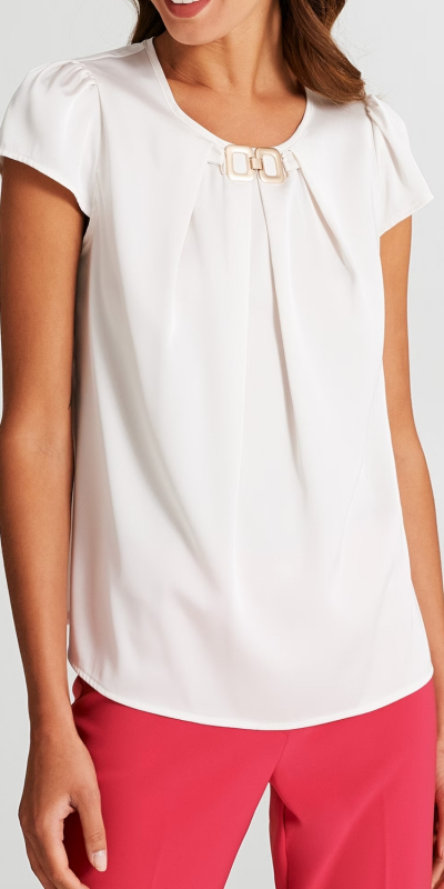 Blusa modello scatoletta con maniche corte, realizzata in raso. 
Scollo rotondo con dettaglio gioiello al centro che stringe il tessuto, creando delle pinces verticali. 
Vestibilità morbida, capo passe-partout da avere nel guardaroba. 
Il capo è interamente made in Italy. La modella è alta 1,77 m ed indossa la taglia S.